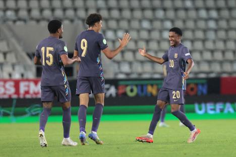 Three England U19 soccer players celebrating a goal.