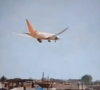 Airplane landing over houses.