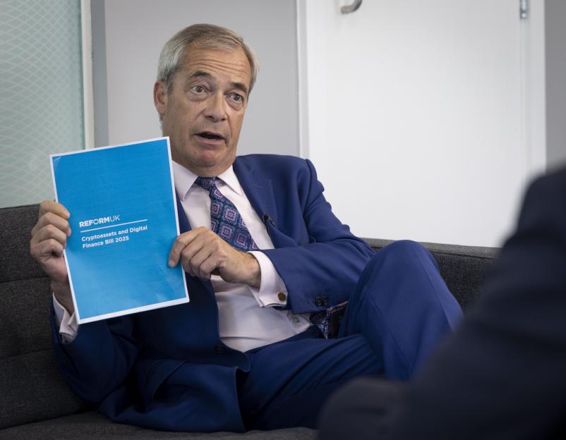 Nigel Farage holding the Reform UK Cryptoassets and Digital Finance Bill 2025.