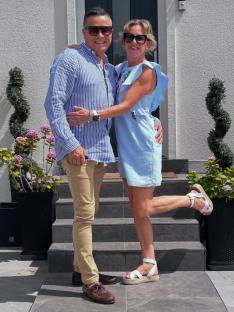 Couple posing on steps outside a house.