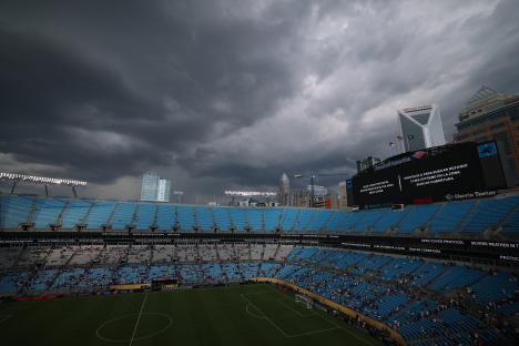 Stadium lights under a stormy sky.