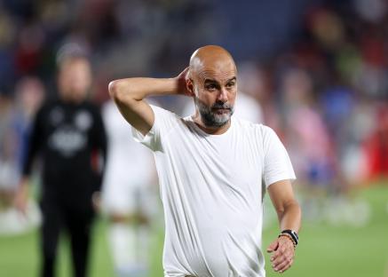Pep Guardiola looking dejected after a soccer game.