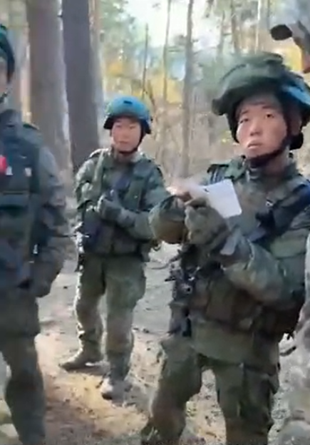 Soldiers in camouflage uniforms in a forest.