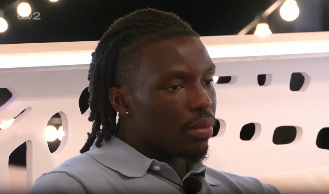 Man with locs looking pensive.