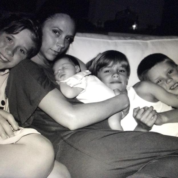 Black and white photo of Victoria Beckham with her four children.