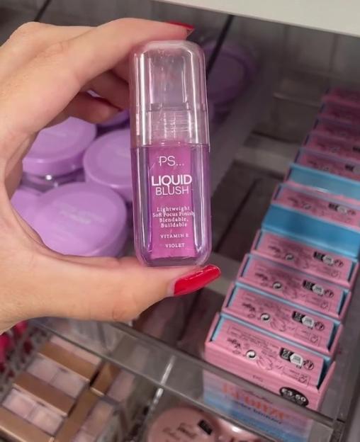 Hand holding a bottle of PS... Liquid Blush in Violet.