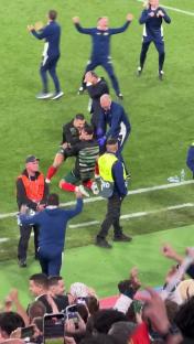 Portugal players huddle together on the field after a penalty shootout.