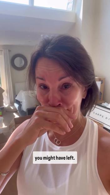 Woman crying while moving boxes.