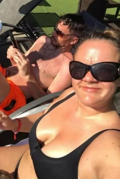 Couple on vacation, man using phone, woman in bikini.