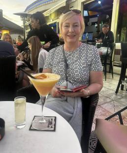 Woman at an outdoor restaurant with a cocktail.