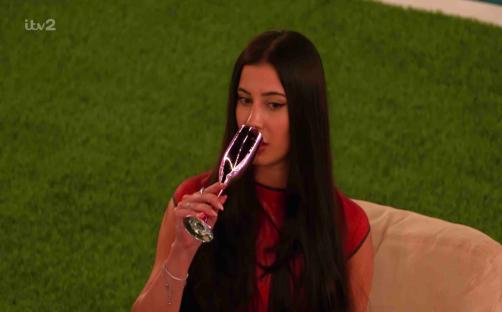 Yasmin from Love Island drinking from a champagne flute.