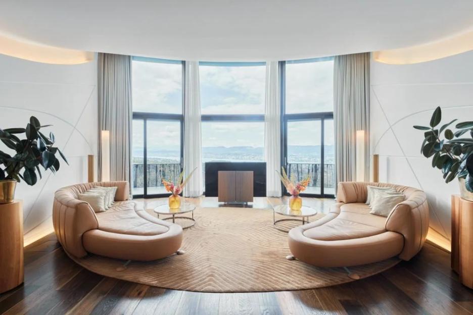 Luxury suite with curved sofas and panoramic views.