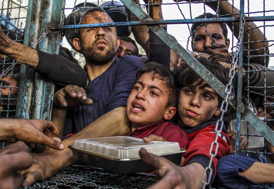 Starving Palestinian children and adults at a food distribution in a Gaza refugee camp.