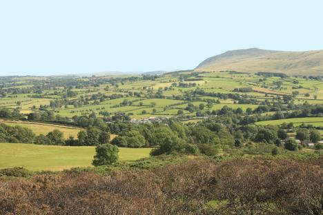 Scenic view of a British countryside with rolling green hills and farmland.