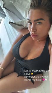 Woman in black swimsuit lying in bed.