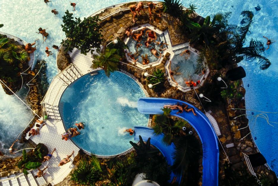 Aerial view of an indoor water park with pools, hot tubs, and water slides.