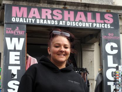 Woman standing in front of Marshalls store.