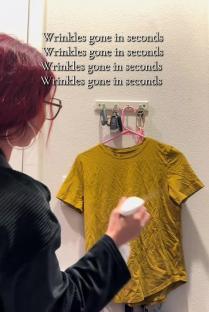Person spraying a wrinkled shirt to remove wrinkles.