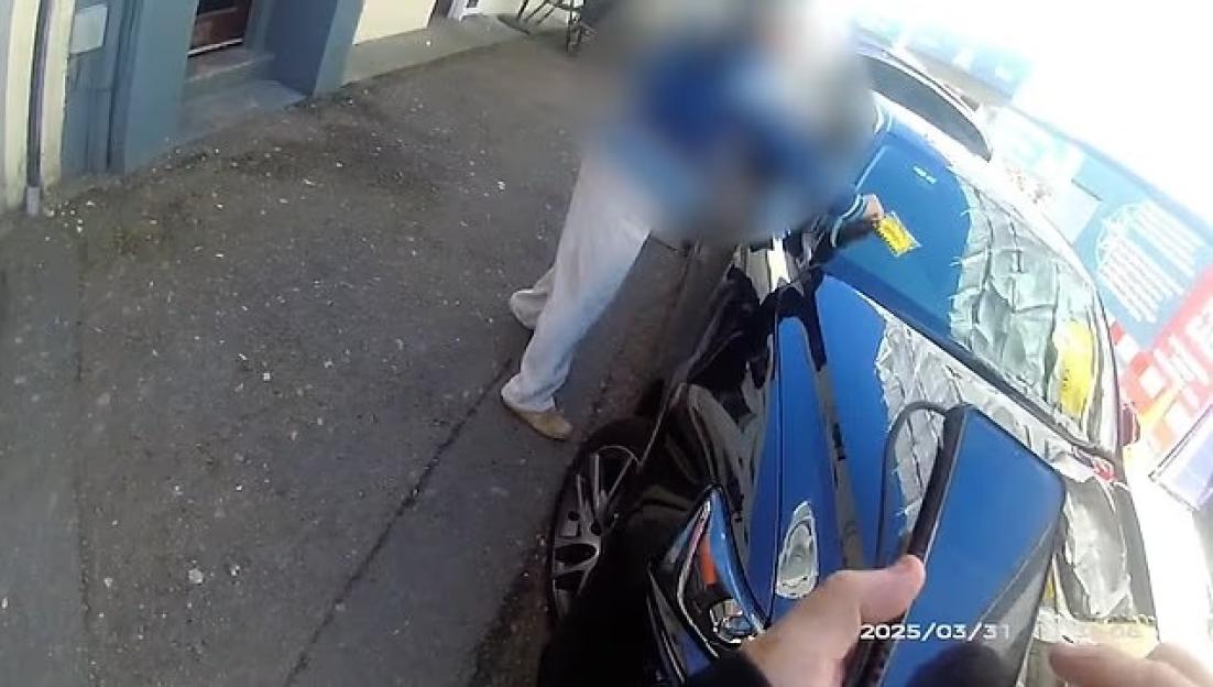 A person dropping a parking ticket on the ground is issued a littering fine.