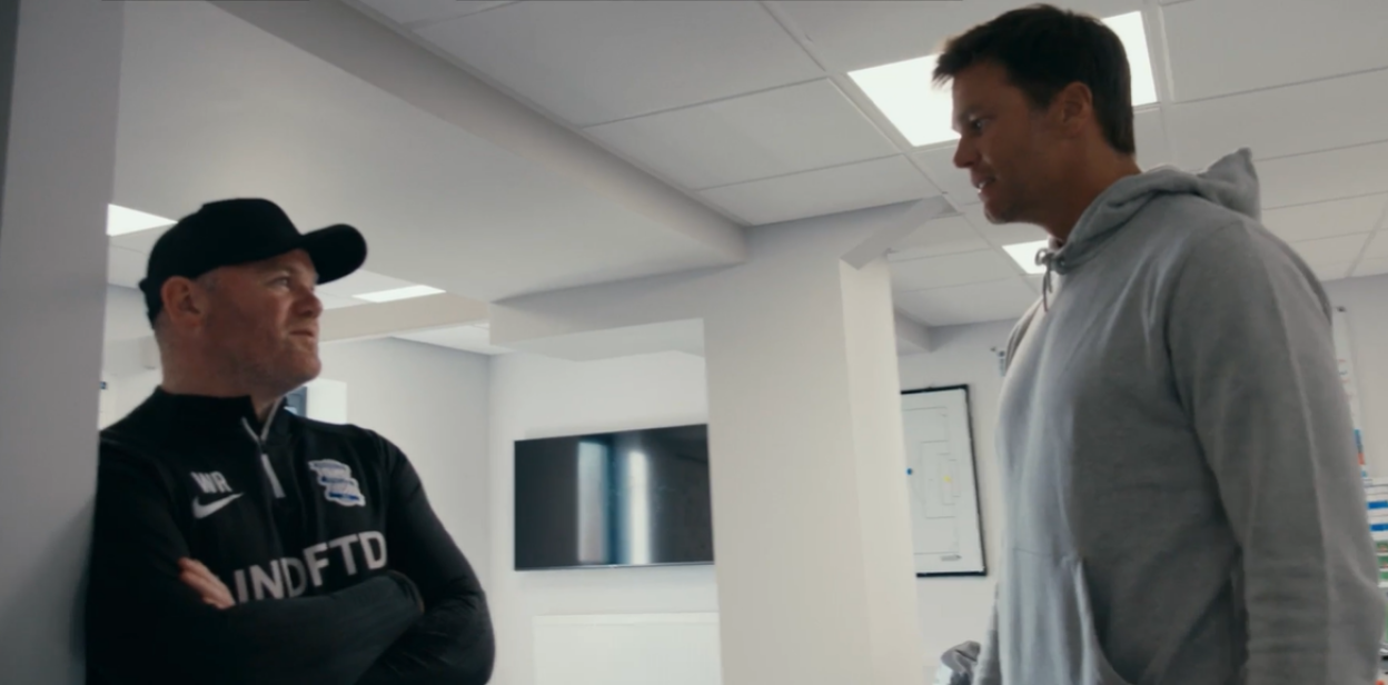 Two men in a hallway having a conversation.