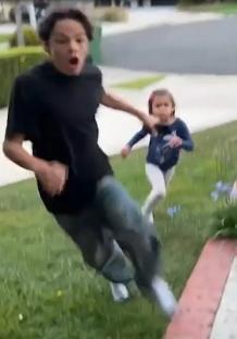 A boy and girl running away from a house after a lightning strike.