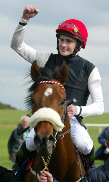 Jockey Pat Smullen celebrating a win on a horse.