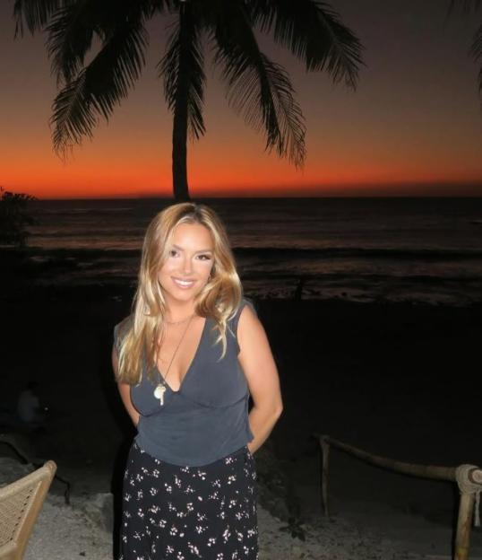Woman smiling at sunset on a beach.