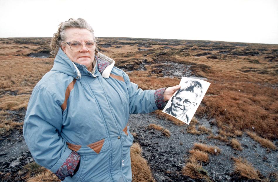 Black and white photo of police searching Saddleworth Moor for victims.