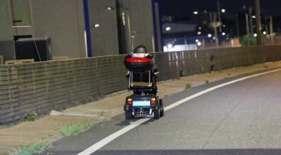 Mobility scooter on a highway at night.