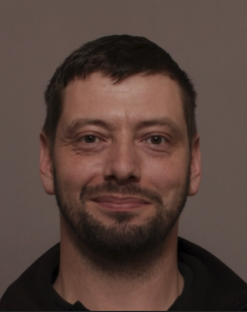 Mugshot of a man with short brown hair and a beard.