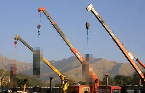Three men hanged from cranes.