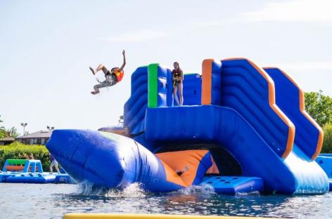 People jumping and playing on an inflatable aqua park.