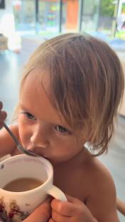 Toddler drinking from a mug.