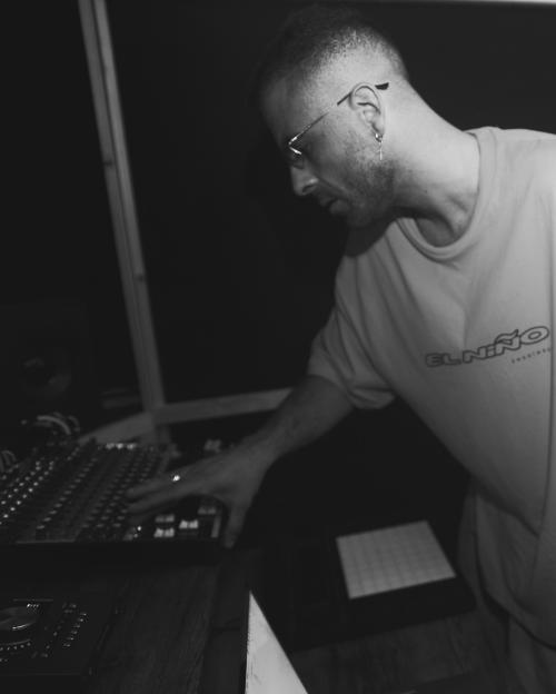 Black and white photo of DJ Godzi at a mixing console.