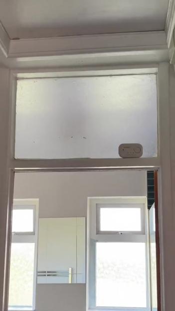 Frosted glass window insert with a small white device on top.