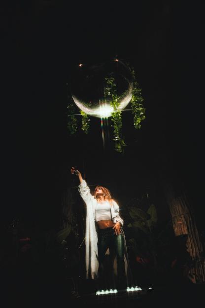 Suki Waterhouse on stage with a disco ball.