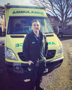 Paramedic Jessie Jeff standing in front of an ambulance.