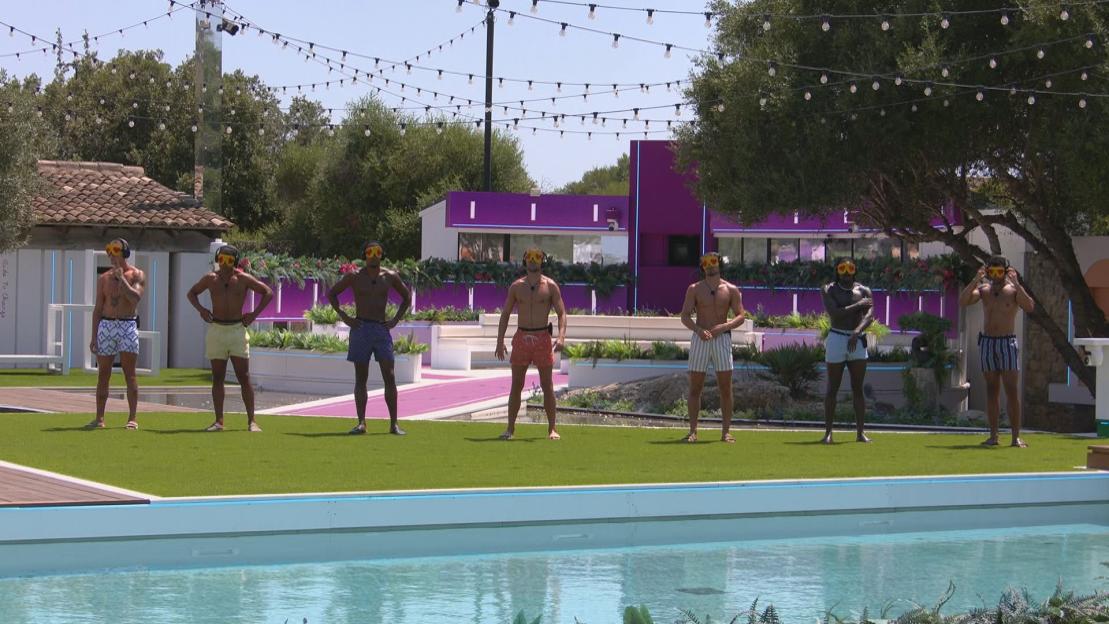 Seven Love Island contestants standing by a pool.