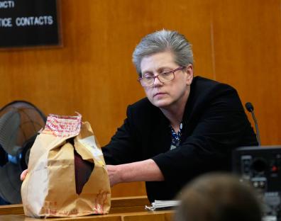 Forensic scientist presenting evidence in court.