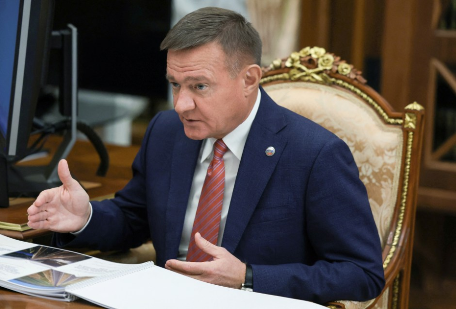 Man in suit speaking at a meeting.