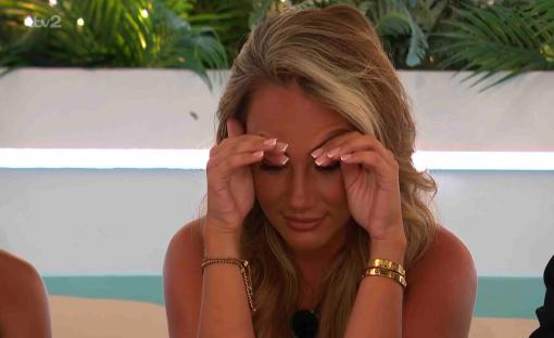Helena from Love Island reacts to a text message.