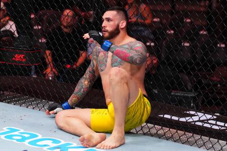 Rodolfo Bellato of Brazil sits against the cage during a UFC fight.