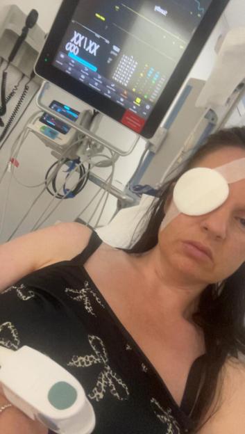 Woman in hospital bed with eye patch.