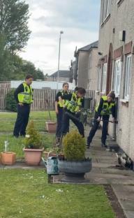 Police officers struggling to break down a door.
