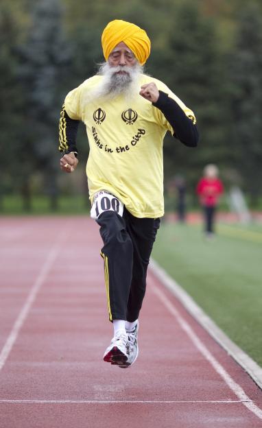 Centenarian Fauja Singh crossing the finish line of a 100-meter race.