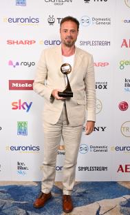 Jamie Theakston holding a TRIC award.
