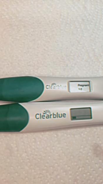 Two Clearblue pregnancy tests, one positive, one negative.