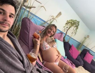 Pregnant woman and man relaxing with drinks.