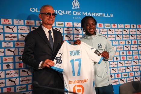 Photo of Fabrizio Ravanelli and Jonathan Rowe at a press conference, holding a soccer jersey.