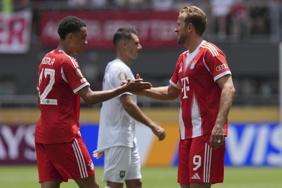 Jamal Musiala and Harry Kane shaking hands after a soccer match.